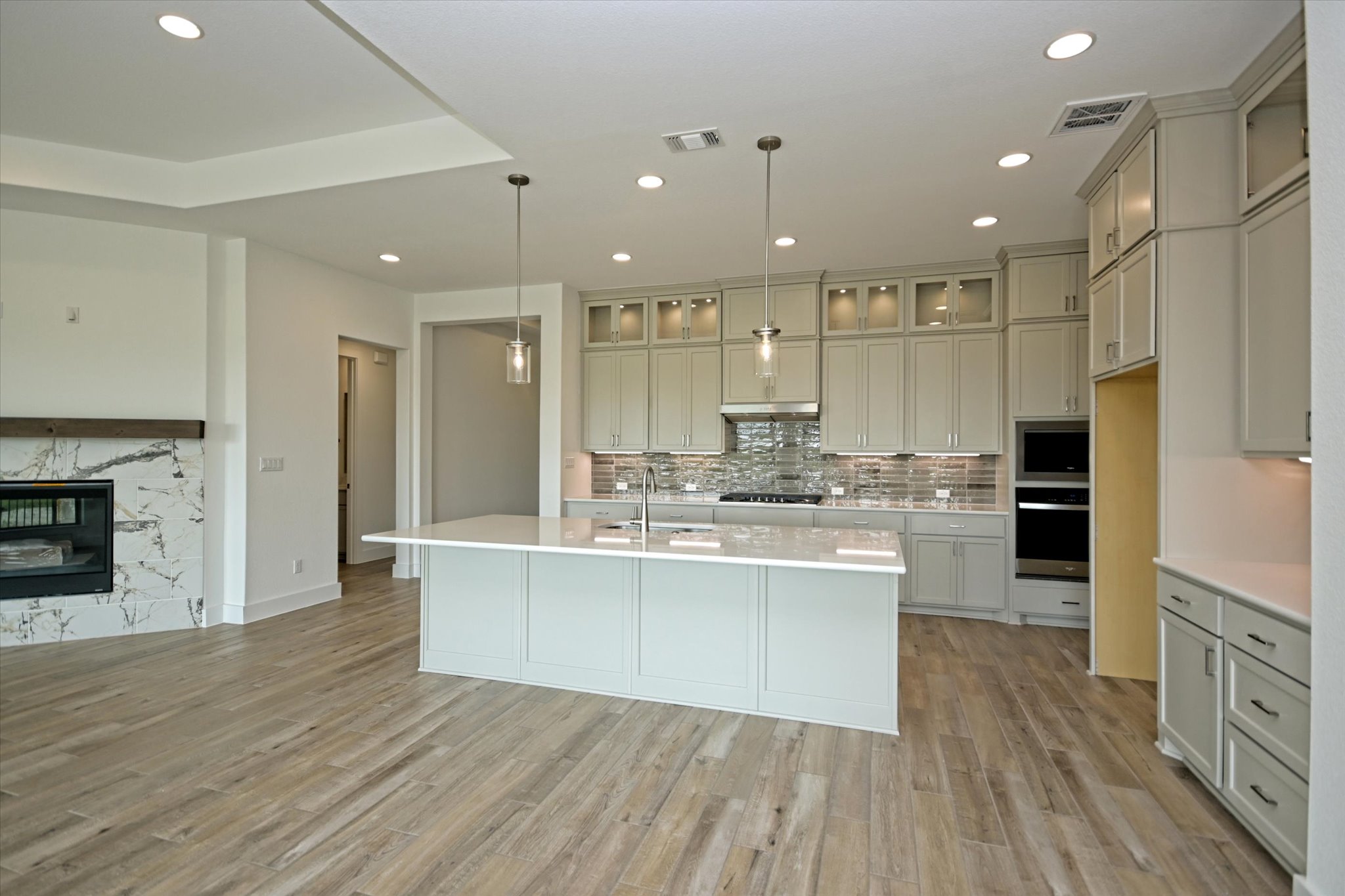 217 Scofield Avenue Georgetown, TX 78626 - Photo 9 of 31 a large kitchen with cabinets wooden floor and stainless steel appliances