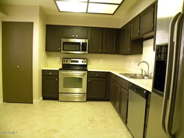 a kitchen with stainless steel appliances granite countertop a stove a sink and a refrigerator