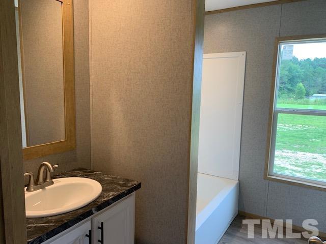 2261 Shoeheel Road Selma, NC 27576 - Photo 13 of 16 a bathroom with a granite countertop sink and a mirror