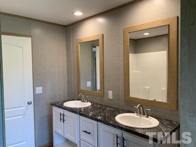2261 Shoeheel Road Selma, NC 27576 - Photo 10 of 16 a bathroom with a granite countertop sink a mirror and a toilet