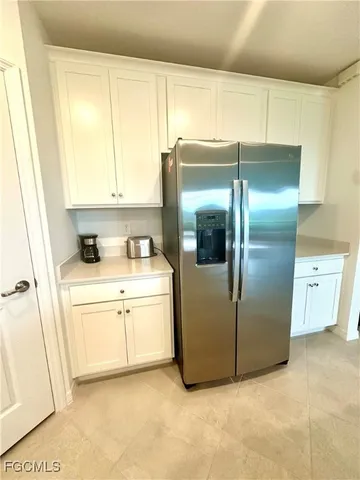 a kitchen with a refrigerator sink and cabinets
