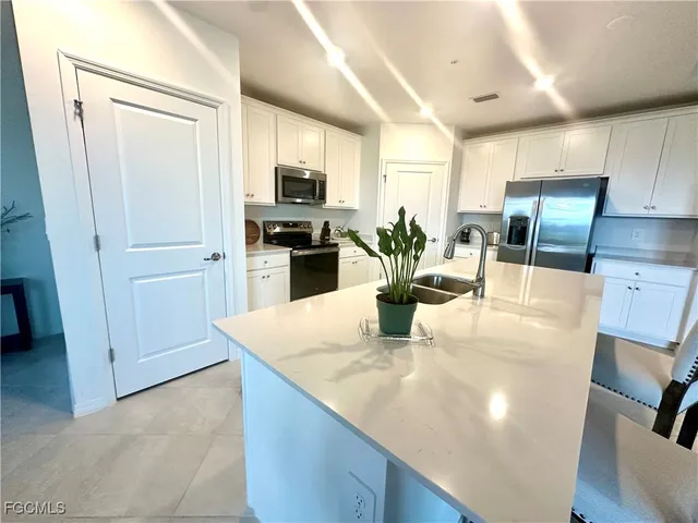 a kitchen with stainless steel appliances granite countertop a sink a stove and a refrigerator