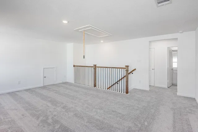 an empty room with staircase and white walls