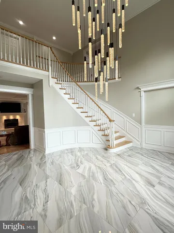 a large kitchen with granite countertop a large white kitchen island a sink stainless steel appliances and cabinets