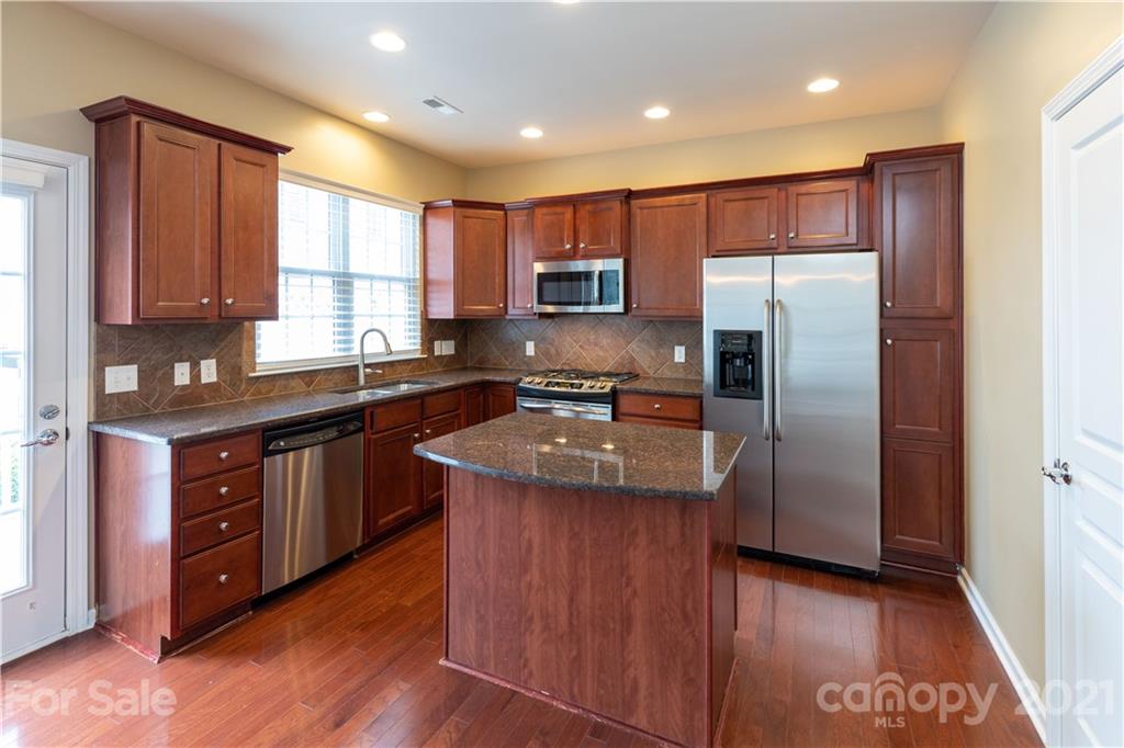 623 6th Baxter Crossing Fort Mill, SC 29708 - Photo 3 of 27 a kitchen with stainless steel appliances granite countertop a refrigerator a sink a stove a microwave and wooden cabinets