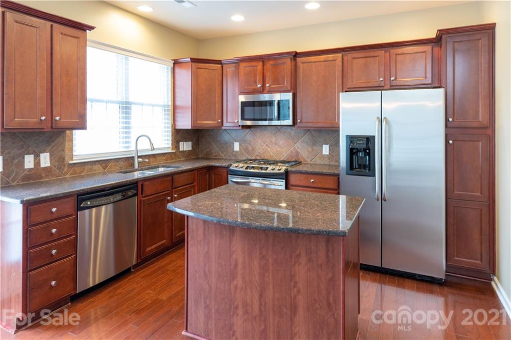 623 6th Baxter Crossing Fort Mill, SC 29708 - Photo 5 of 27 a kitchen with a sink a center island stainless steel appliances and cabinets