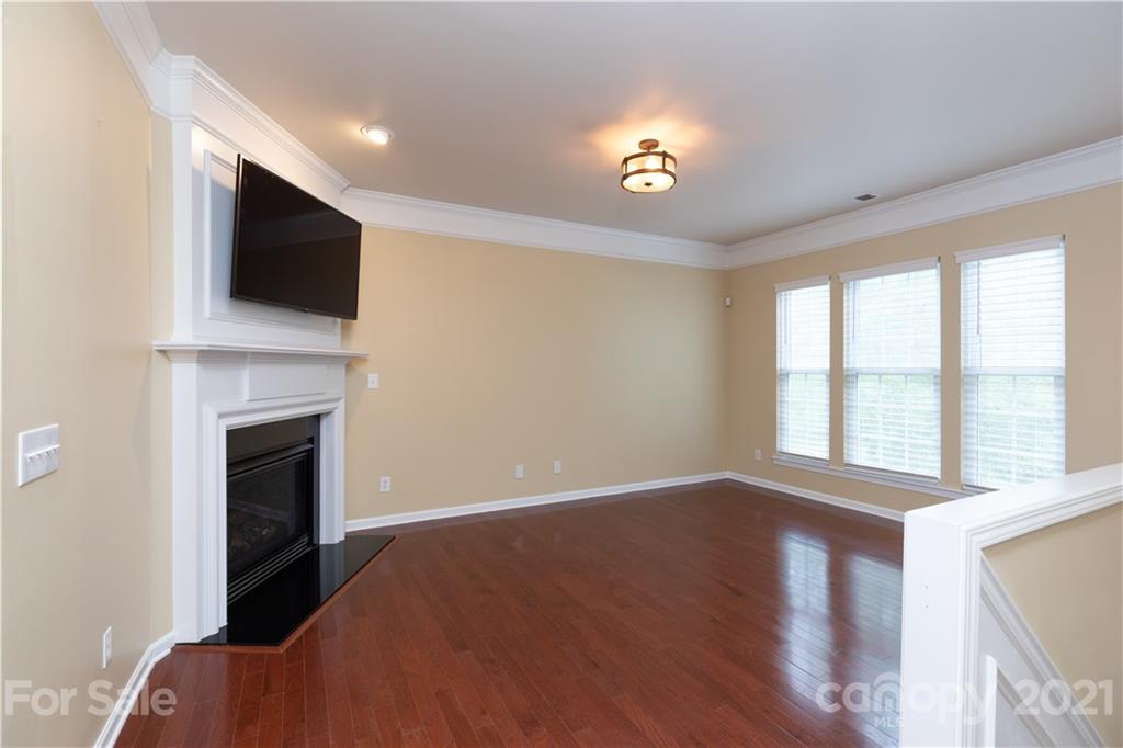 623 6th Baxter Crossing Fort Mill, SC 29708 - Photo 9 of 27 a view of an empty room with wooden floor fireplace and a window