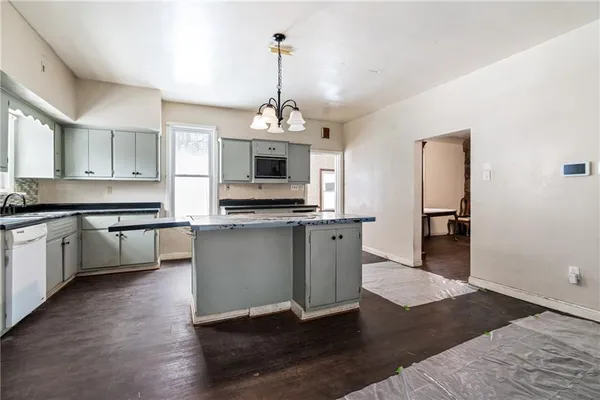 a kitchen with kitchen island granite countertop a sink cabinets and stainless steel appliances