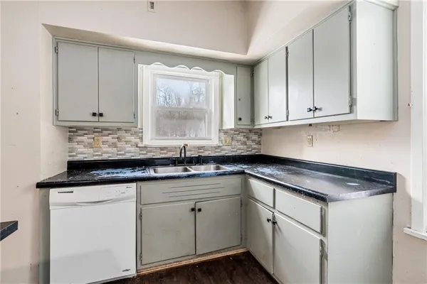 a kitchen with granite countertop white cabinets and white appliances