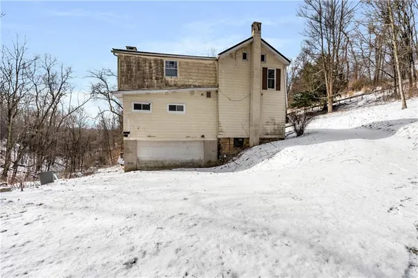 a front view of a house with a yard covered in snow