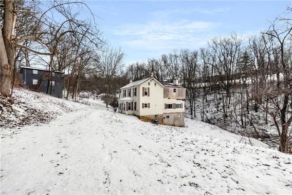 a view of white house with a snow on the road