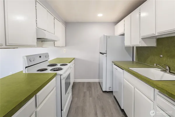 a kitchen with a sink a stove and cabinets