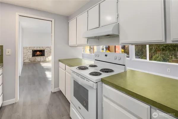 a kitchen with a stove and a white cabinets