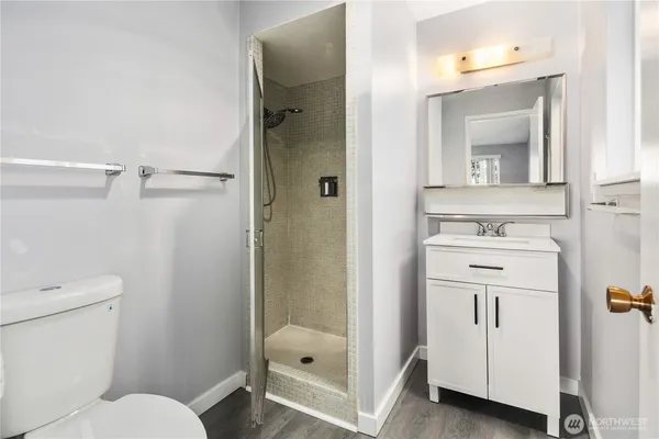 a bathroom with a sink a toilet and shower
