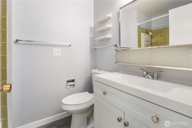 a bathroom with a granite countertop toilet sink and mirror