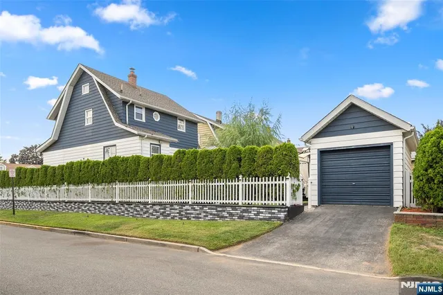 a view of a house with a small yard and wooden fence