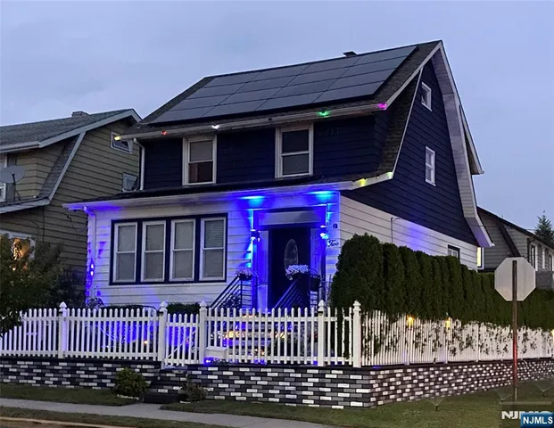 a view of a house with a small yard and wooden fence