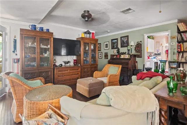 a living room with furniture kitchen view and a flat screen tv