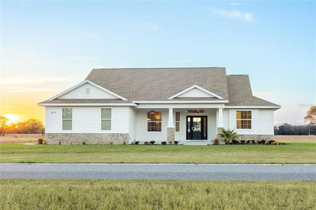 a front view of a house with a garden and plants