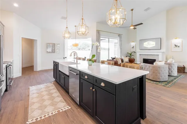 a kitchen with a stove a sink dishwasher and a fireplace with wooden floor