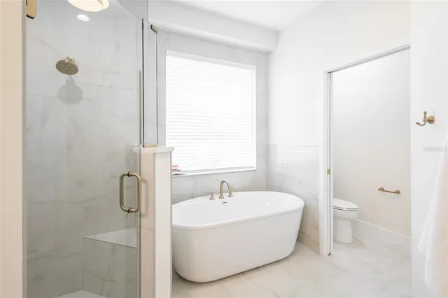 a bathroom with a granite countertop sink a toilet and shower
