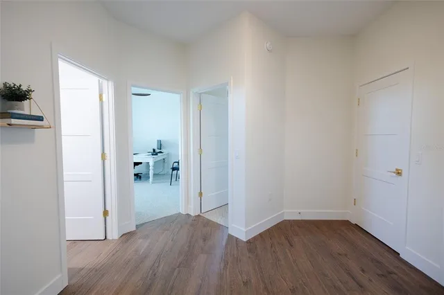 a view of a hallway with wooden floor and staircase