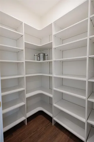 a view of a hallway with wooden floor and windows