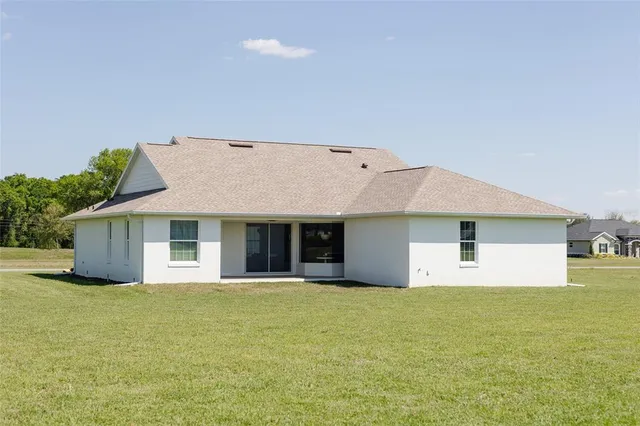 a front view of house with yard and trees in the background