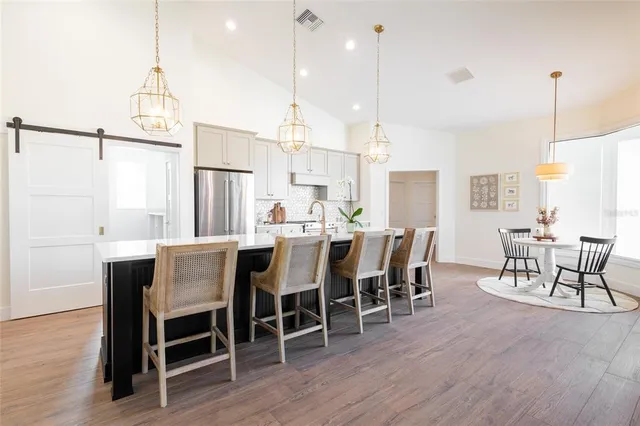 a dining room with furniture a chandelier and wooden floor