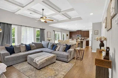 a living room with furniture ceiling fan and a window
