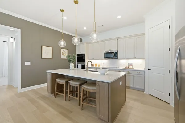 a kitchen with kitchen island a sink a center island stainless steel appliances and cabinets