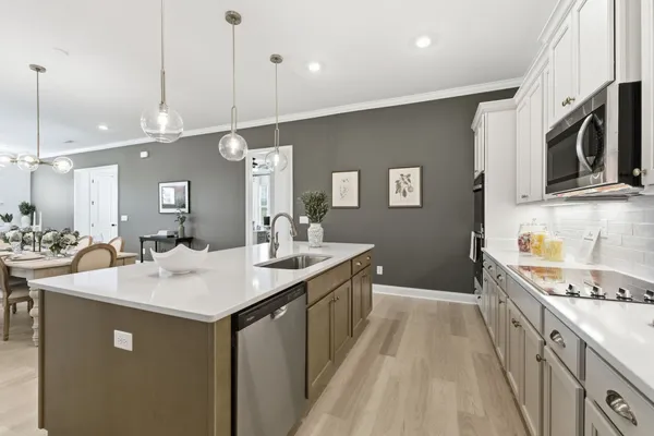 a kitchen with stainless steel appliances granite countertop a sink a stove and a wooden floors