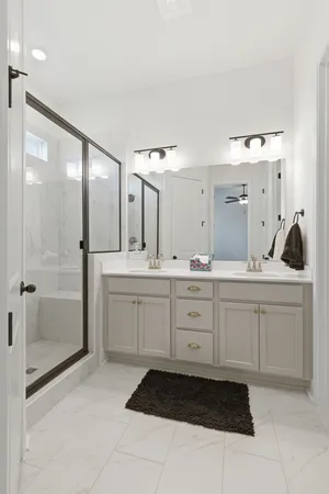 a spacious bathroom with a shower sink and mirror