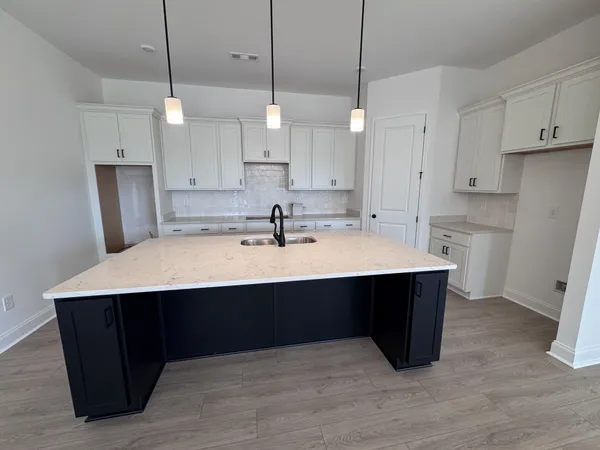 a kitchen with kitchen island a sink stainless steel appliances and white cabinets