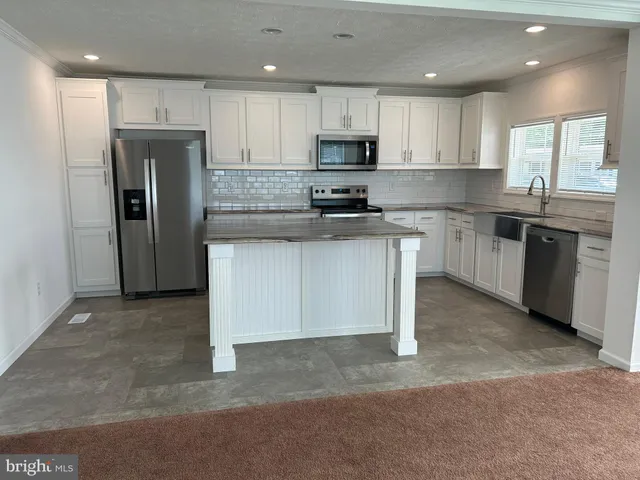 a kitchen with stainless steel appliances granite countertop a refrigerator stove top oven and sink