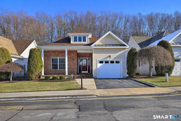 a front view of a house with a yard covered in snow