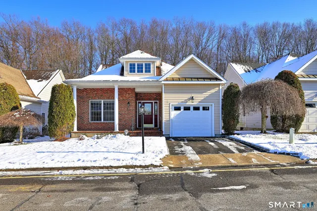 a front view of a house with a yard covered in snow