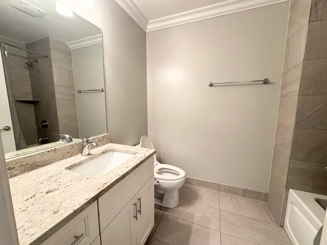 a bathroom with a granite countertop sink toilet and shower
