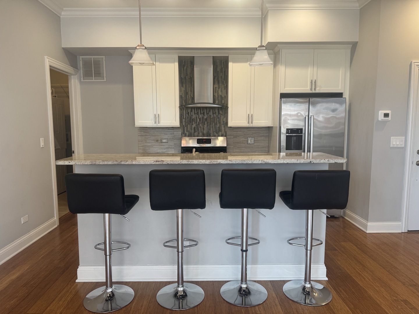 951 West Huron Street, Unit 402 Chicago, IL 60642 - Photo 2 of 18 a kitchen with stainless steel appliances kitchen island granite countertop a table and chairs in it