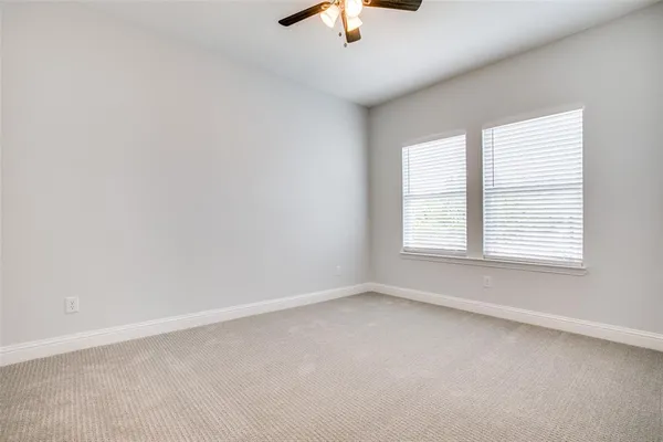 an empty room with a window and a ceiling fan