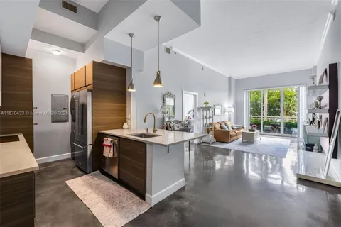 a kitchen with stainless steel appliances a stove a refrigerator a sink dishwasher a oven and a dining table with wooden floor