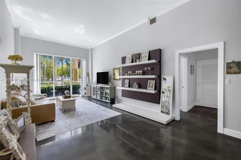 a living room with furniture a flat screen tv and floor to ceiling window