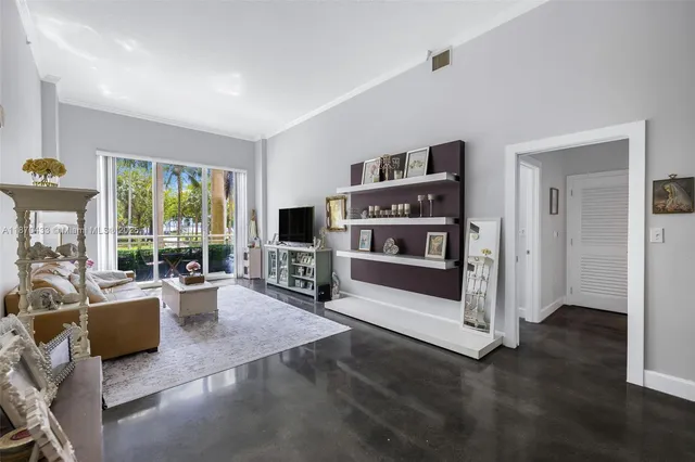 a living room with furniture a flat screen tv and floor to ceiling window