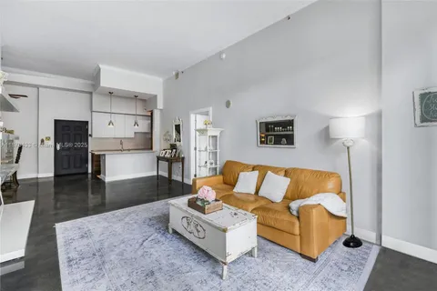 a living room with furniture and a kitchen view