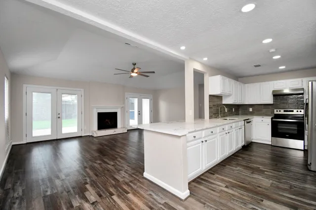 a kitchen with granite countertop a stove top oven and sink