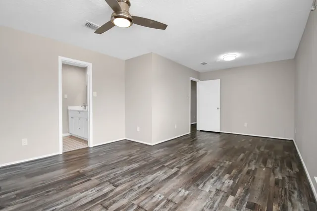 a view of an empty room with wooden floor
