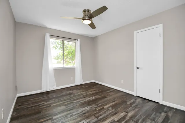 a view of an empty room with wooden floor