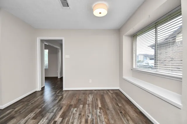 a view of a room with wooden floor and window