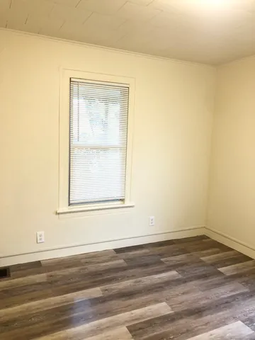 a view of a small space with wooden floor and a window