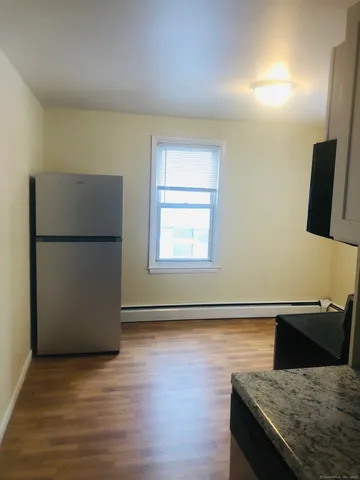a kitchen with granite countertop a refrigerator and a sink
